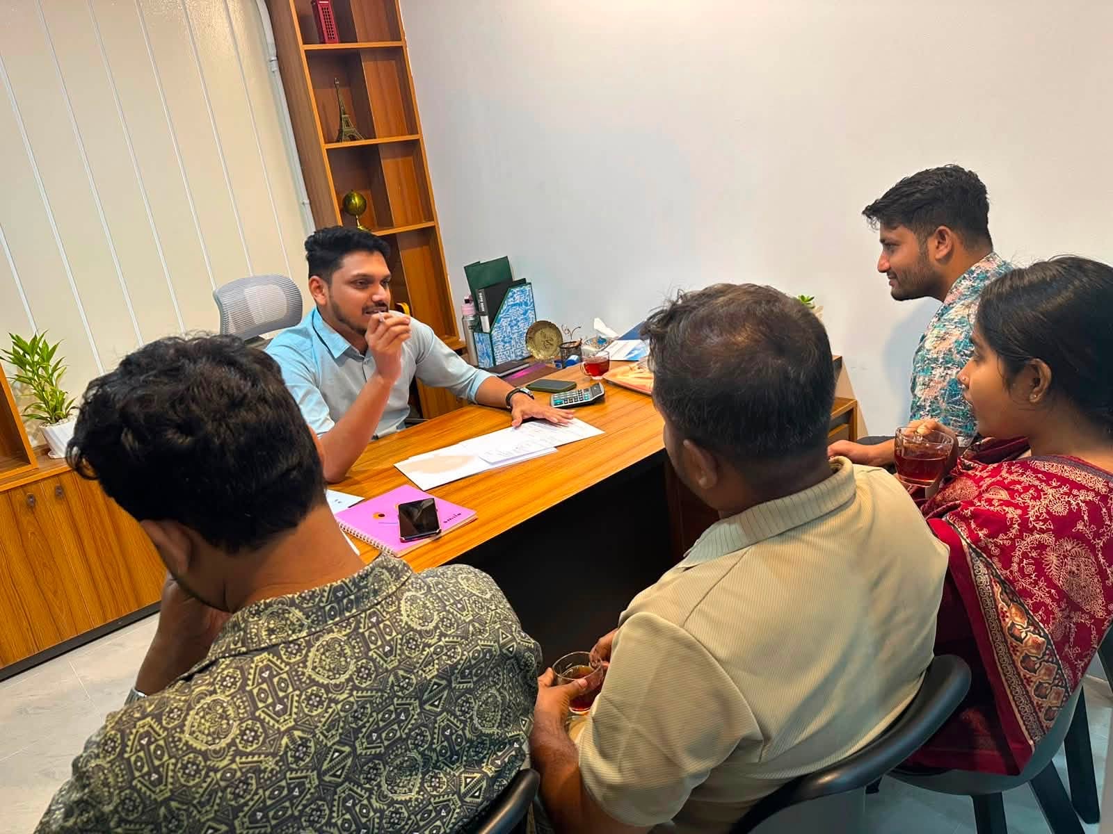 A family reviewing an application with an adviser at the consultation desk